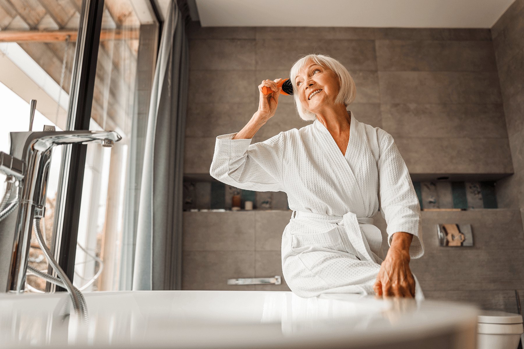 Altersgerechtes Badezimmer mit bodengleicher Badewanne, rutschfesten Oberflächen und großzügigem Bewegungsraum für sicheres und selbstständiges Nutzen.