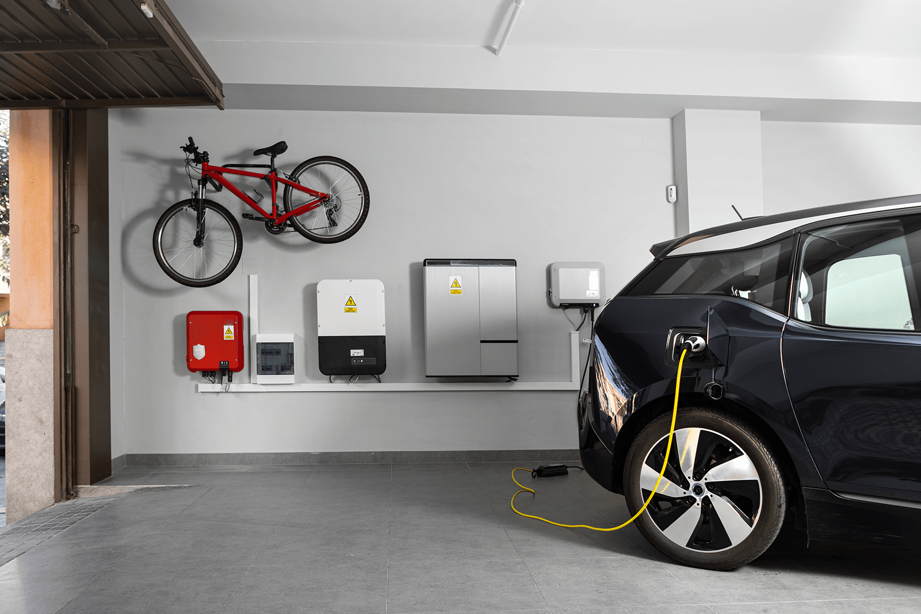 Du siehst eine Garage mit Elektroauto, Wallbox und Haustechnik, die dir zukunftssichere Mobilität und Ordnung im Alltag ermöglicht.