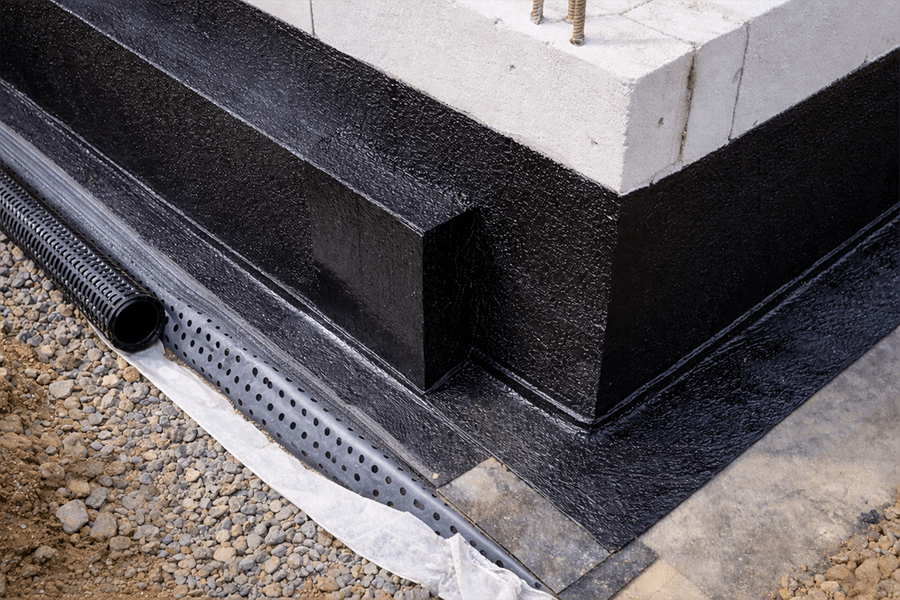 Rohbau eines Kellers mit Betonwänden und Bewehrung auf einer Baustelle in einem Wohngebiet.